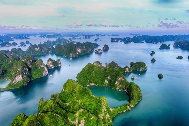 Aerial view of Halong Bay’s limestone islands Drone view of Halong Bay’s emerald waters dotted with limestone islands and green coves