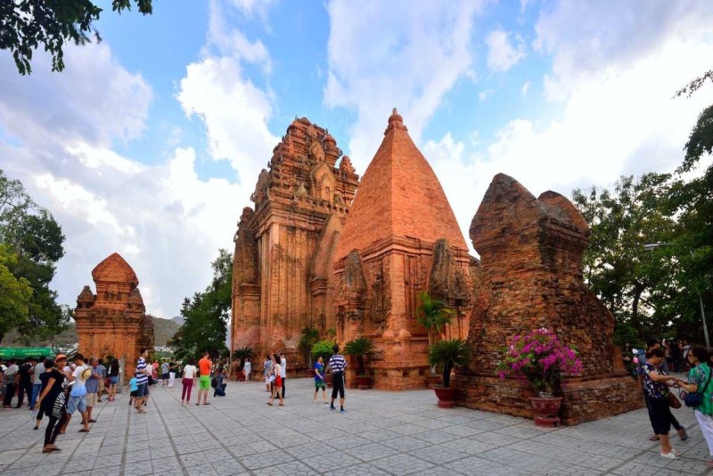 Cham Po Nagar Towers Temple Grounds and Visitors Tourists walking around the temple grounds of Cham Po Nagar Towers in Nha Trang under partly cloudy skies