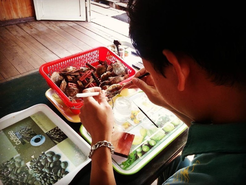 Crafting Pearls at Tung Sau Pearl Farm A pearl technician carefully handles oysters as part of the intricate pearl-making process at Tung Sau Pearl Farm.
