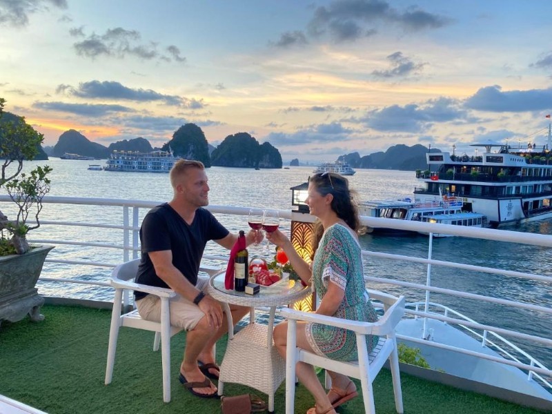 Elegant sunset dinner on Ha Long Bay cruise Couples enjoy a sunset dinner cruise on Ha Long Bay with a relaxing and elegant atmosphere.