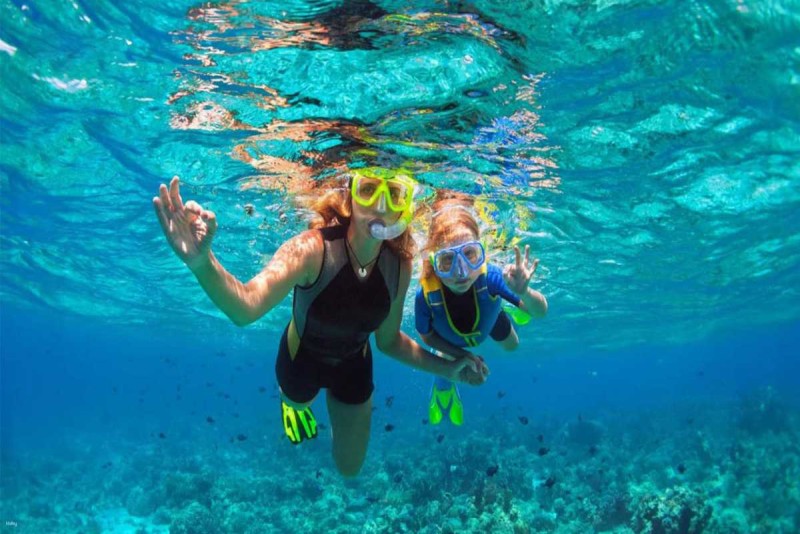 Family snorkeling together at Mun Island Family enjoying snorkeling together in the clear waters of Mun Island surrounded by vibrant fish