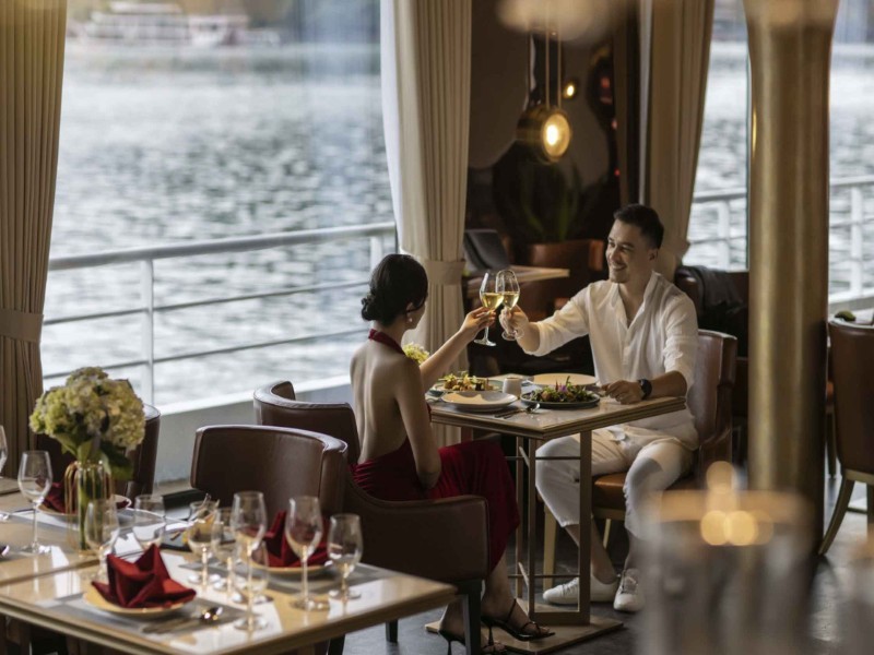 Fine dining on Ha Long Bay luxury cruise Guests enjoy fine dining on a luxury Ha Long Bay cruise with an exceptional view of the bay’s serene waters.