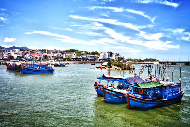 Fishing Boats and River Bridge at Cai River Nha Trang Fishing boats moored near a river bridge at Cai River Nha Trang, showcasing river life and swimming areas