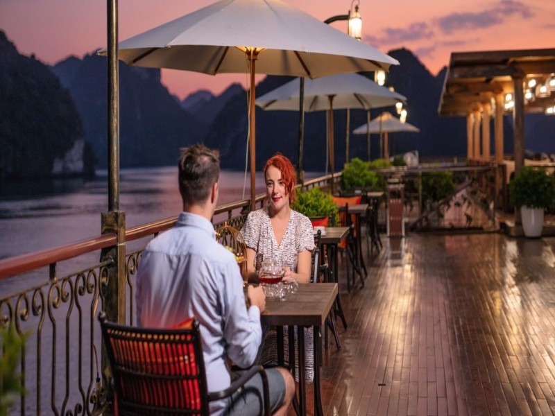 Intimate dining on Ha Long Bay luxury cruise Guests enjoy a private, intimate dinner on a Ha Long Bay cruise, overlooking the breathtaking natural beauty.