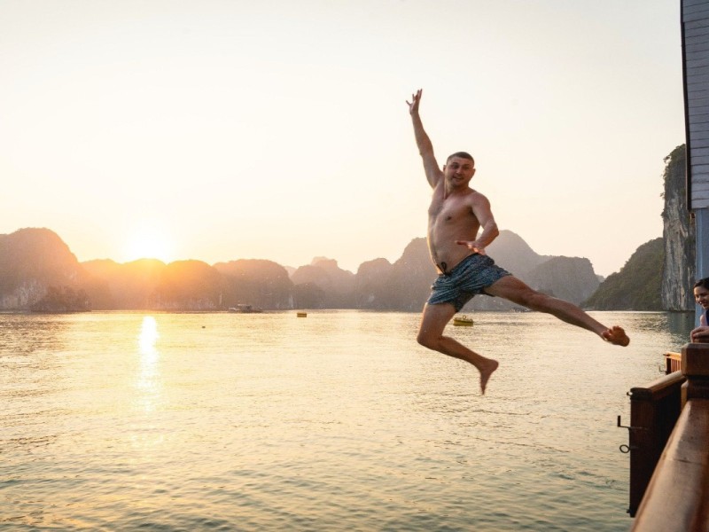 Relaxation and Fun in Halong Bay Waters Families and friends enjoying a swim in Halong Bay’s pristine emerald waters with scenic views.