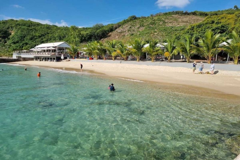Relaxing Beach Swim at Tranh Beach Nha Trang Visitors swimming and walking along the sandy beach with calm, clear water and tropical surroundings at Tranh Beach.