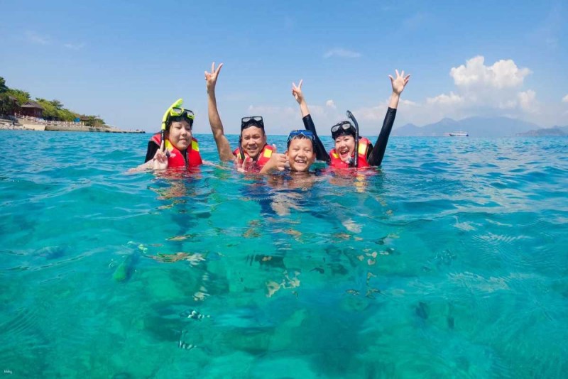 Snorkeler swimming over coral reefs at Mun Island Snorkeler exploring the diverse coral reefs beneath the surface at Mun Island, Nha Trang