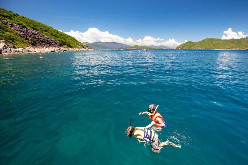 Snorkelers Diving into the Waters of Hon Mot Island Tourists diving and snorkeling in the pristine blue waters around Hon Mot Island, Nha Trang