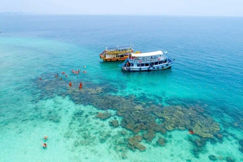 Snorkeling Spots at Mun Island Boat Cruise Snorkelers swimming near coral reefs with boats anchored close by at Mun Island