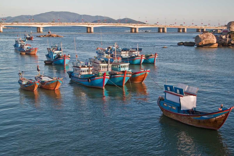 Traditional Fishing Boats Anchored on Cai River Traditional wooden fishing boats anchored on Cai River near Nha Trang city under clear sky
