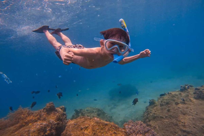 Young Snorkeler Enjoying Clear Waters at Hon Mot Island Child snorkels over coral formations in the clear blue waters of Hon Mot Island near Nha Trang