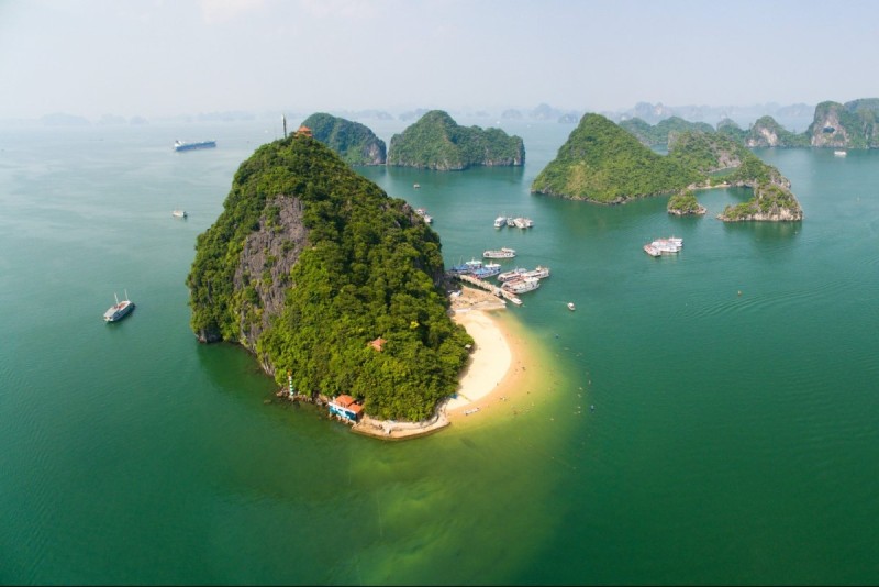 aerial-view-titov-island-halong-bay.jpg An aerial view of Titov Island in Halong Bay, with emerald green waters and surrounding limestone islands.