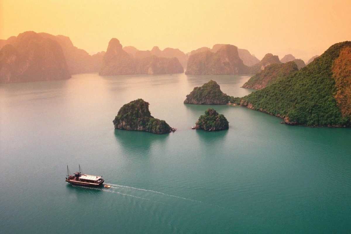 Aerial view of Ba Ham Lake Halong Bay featuring dramatic limestone karsts rising from emerald green waters.