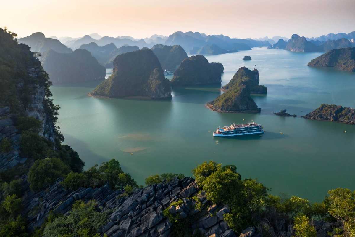 Serene freshwater lake surrounded by towering limestone karsts at Ba Ham Lake Halong Bay