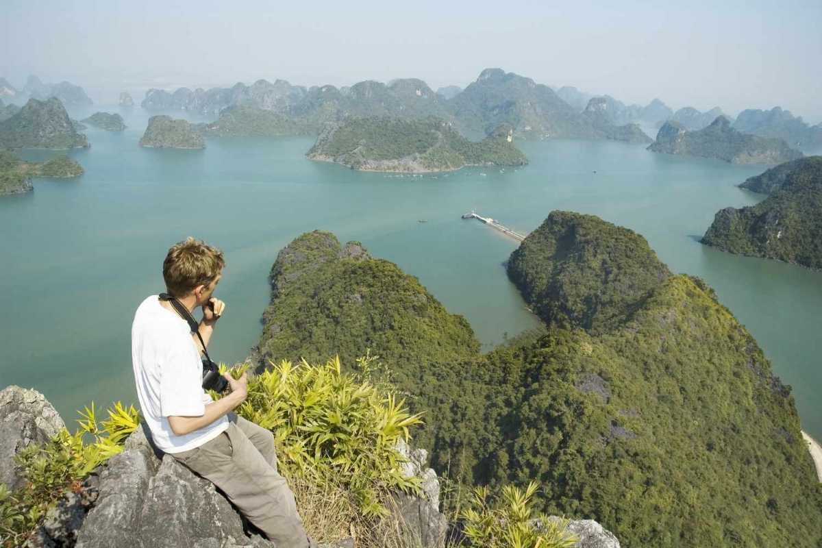 Traditional junk boat sailing gracefully through Ba Ham Lake Halong Bay’s emerald waters