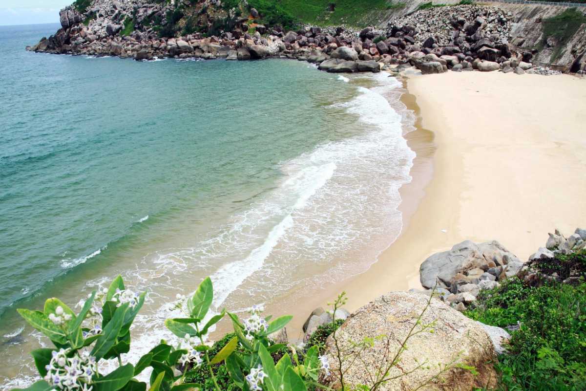 Visitors swimming and relaxing on the pebble beach at Bai San Beach, Nha Trang