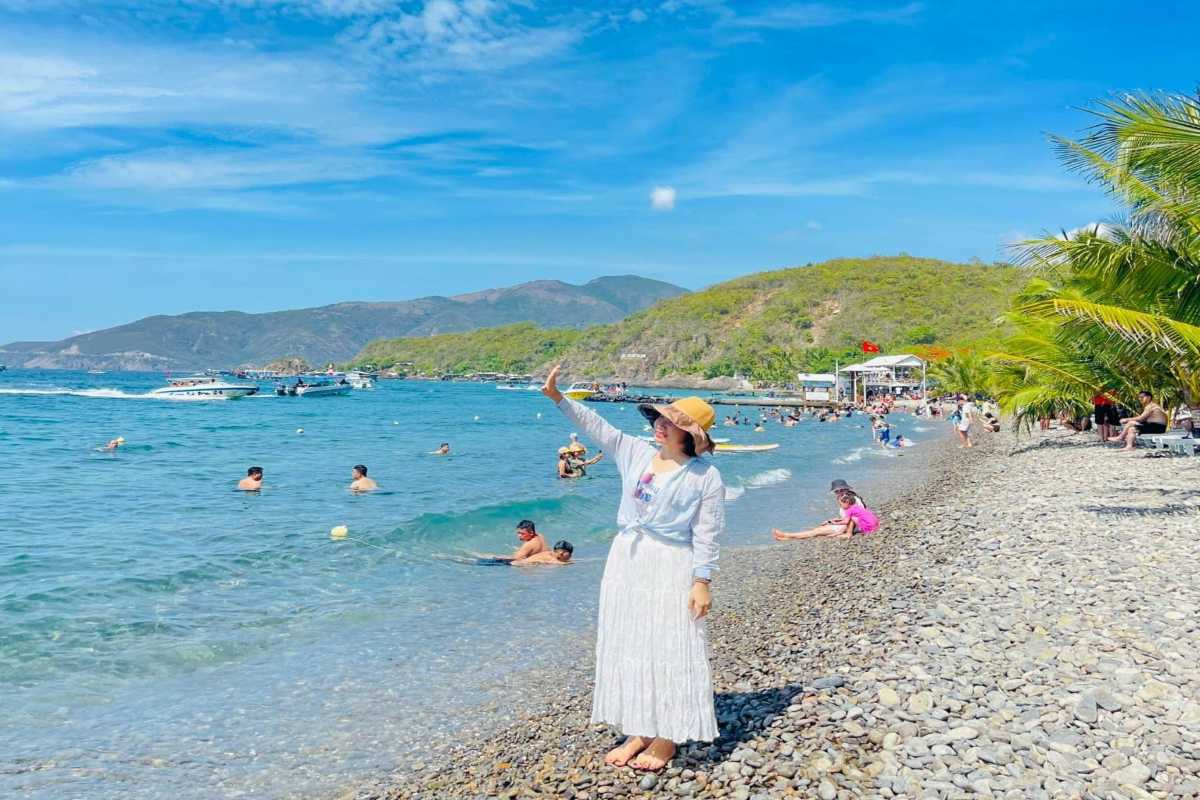 Small cove with sun umbrellas and boats moored at Bai San Beach, Nha Trang