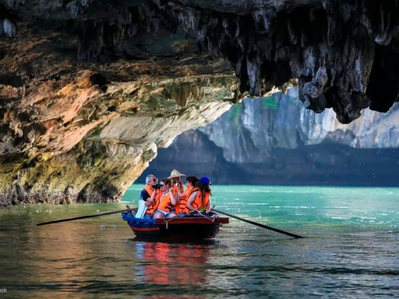 Bamboo Boat Passing Through the Bright Cave Entrance Bamboo boat passing through Bright Cave entrance in Halong Bay