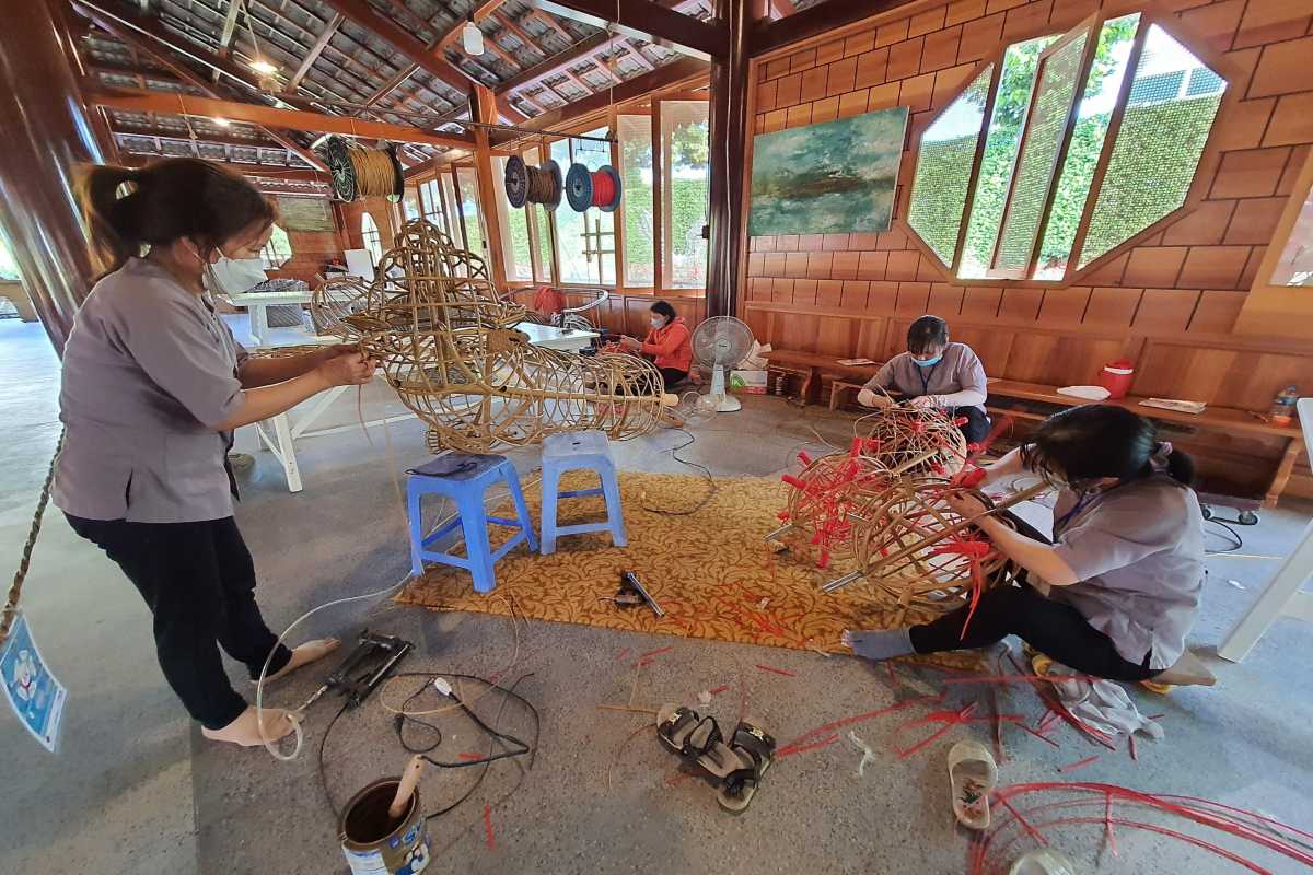 Bamboo Frame Handcrafting at Village Workshop Women constructing animal-shaped bamboo frames by hand inside a structured handicraft center near the Cai River in Nha Trang.