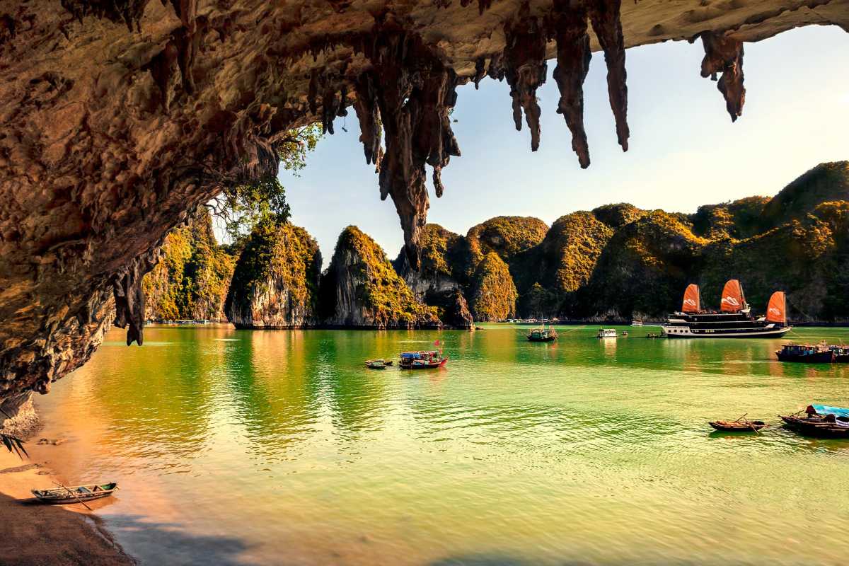 Bo Nau Cave Halong Bay features dramatic limestone islands and clear blue waters with a traditional boat.