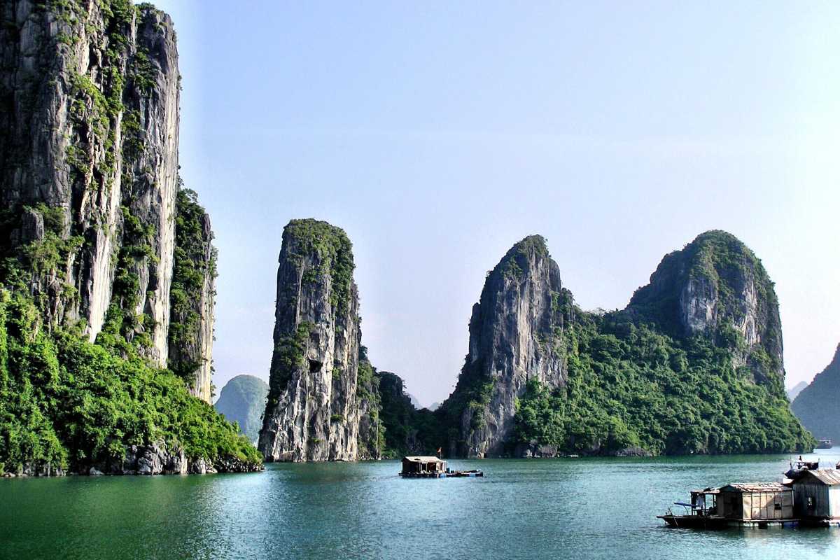 A picturesque scene from Bo Nau Cave in Halong Bay, with clear waters and towering limestone formations.