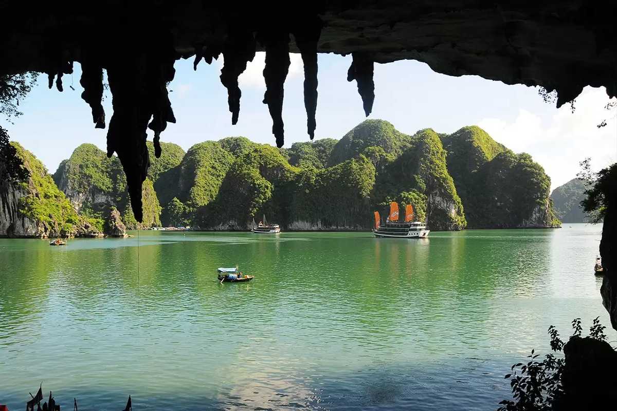 Scenic Bo Nau Cave Halong Bay with traditional boats floating near limestone cliffs, offering a calm escape.