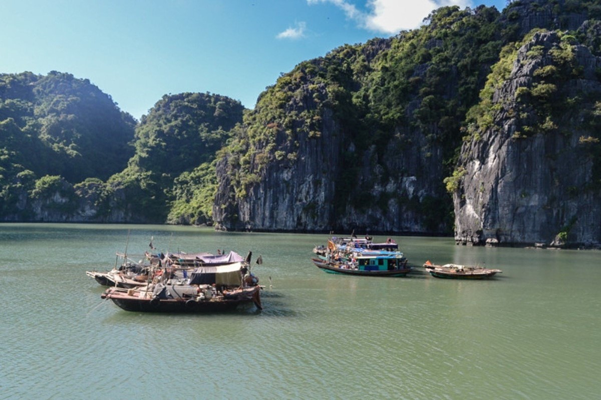 Cap La Island traditional fishing boats in Bai Tu Long Bay, showcasing the local fishermen's way of life amidst limestone karsts.