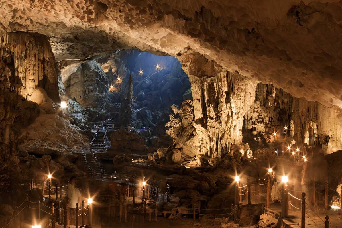 Vast chamber inside Sung Sot Cave Halong Bay lit with warm lights highlighting towering rock formations