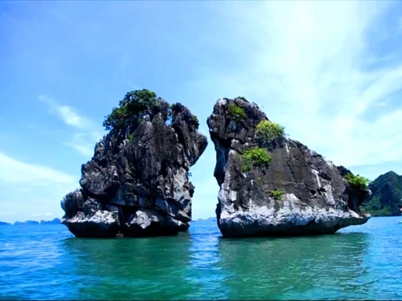 Close-Up of Fighting Cocks Islet in Halong Bay Close-up of the famous Fighting Cocks Islet in Halong Bay, showing the unique limestone formation in the blue waters.