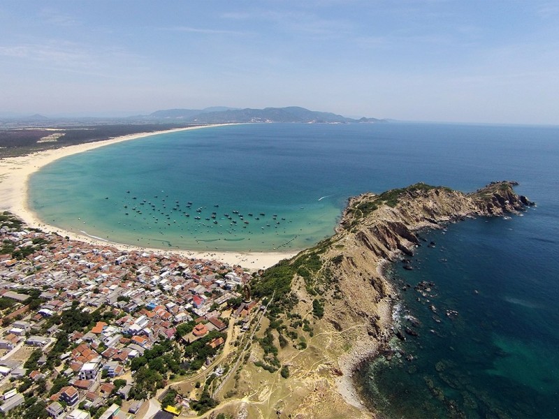 Aerial view of the coastal village and shoreline on Quan Lan Island.