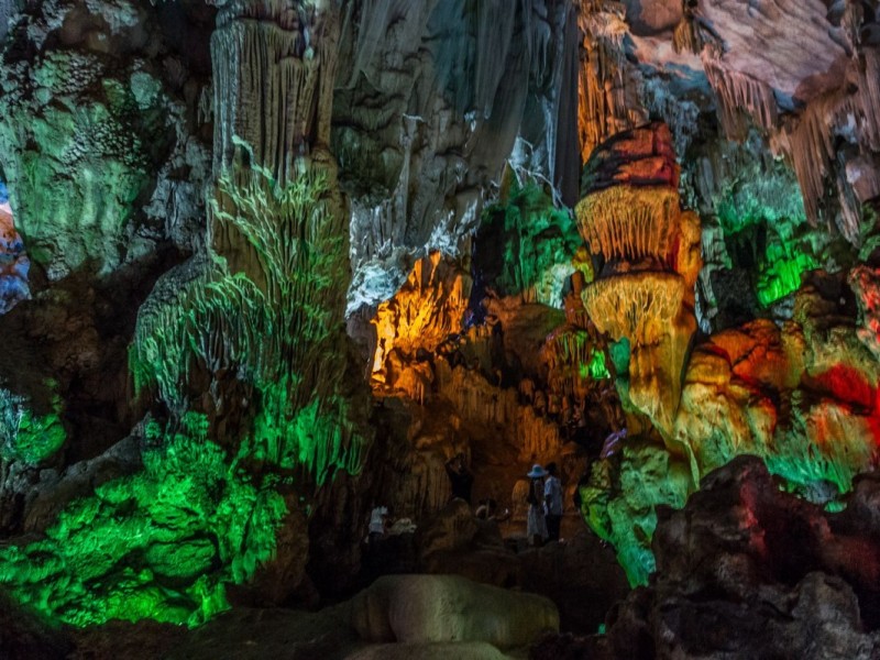 Colorful Interior of Dau Go Cave in Ha Long Bay Illuminated interior of Dau Go Cave with vibrant colors reflecting on limestone formations in Ha Long Bay