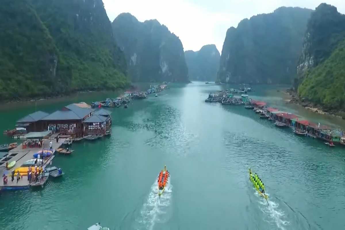 Scenic view of Cong Dam Fishing Village with traditional wooden boats and limestone karsts in Bai Tu Long Bay