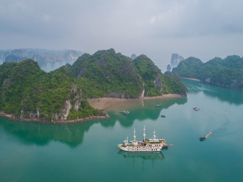 Cruise Through Cong Dam Area with Stunning Limestone Scenery Cruise ship passing through the scenic Cong Dam Area with limestone karsts and pristine waters in Bai Tu Long Bay.