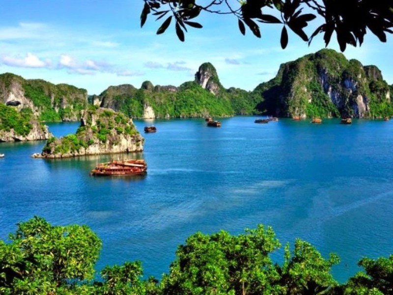Scenic view of a cruise boat approaching Thien Canh Son Cave in Bai Tu Long Bay.