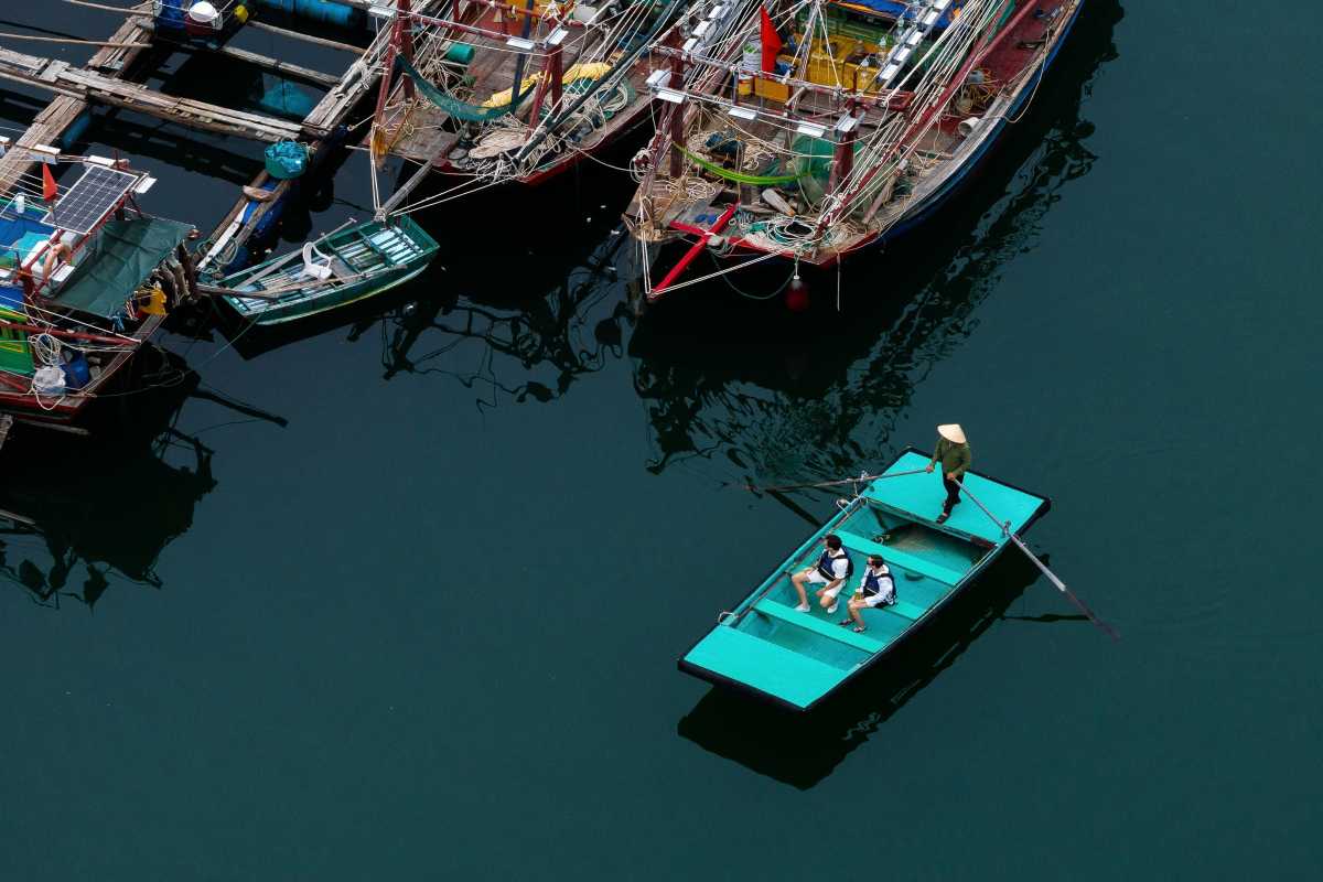 Wooden traditional boats docked at Cua Van Floating Village Halong Bay with fishing nets and equipment visible