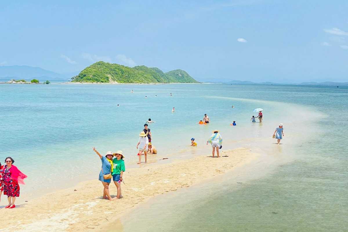 Visitors Walking on Diep Son Island Sandbar Pathway Tourists walking on the natural sandbar connecting small islands at Diep Son Island Nha Trang