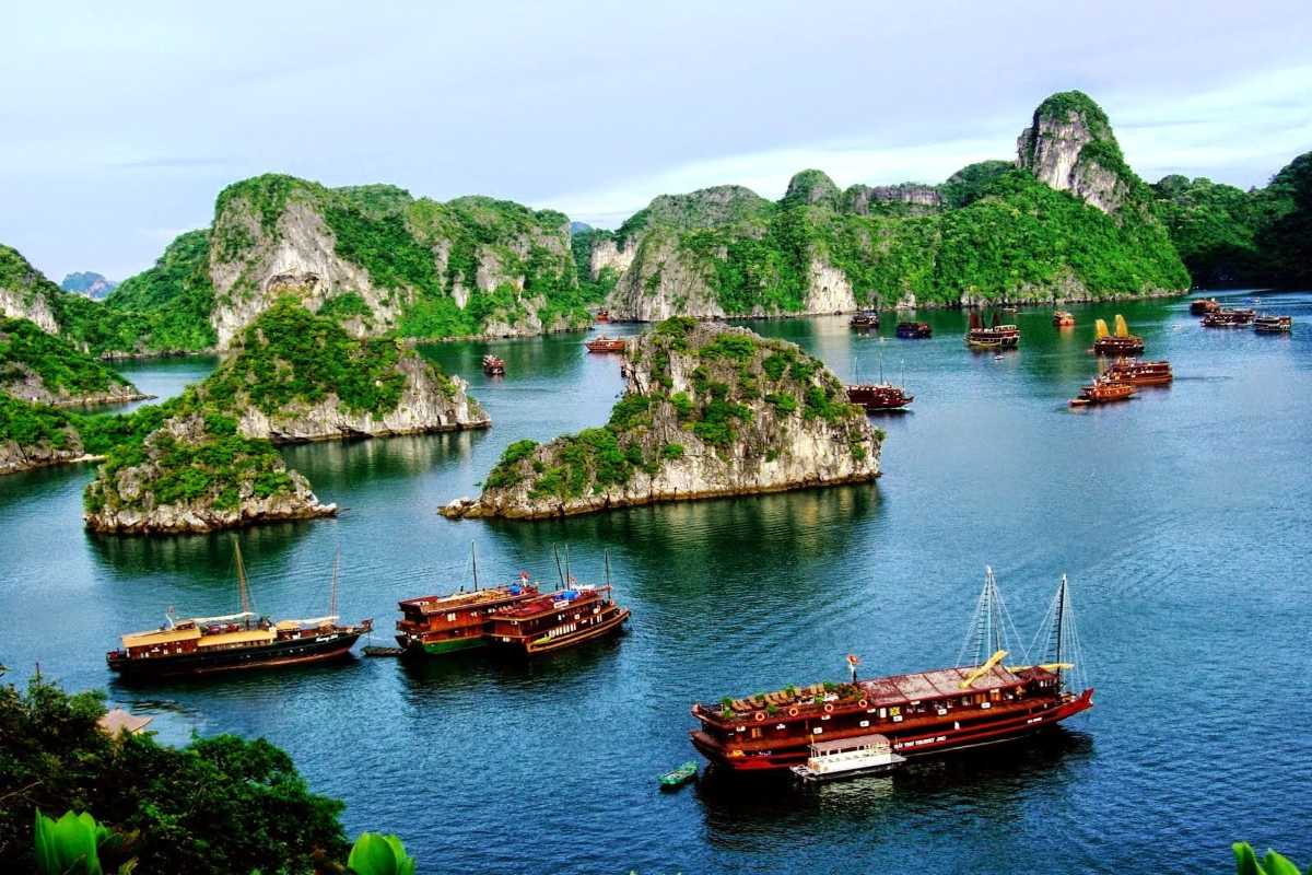 Limestone rock formation at Dinh Huong Islet Halong Bay surrounded by traditional wooden boats