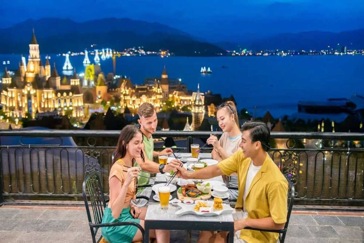 Dining Experience at VinWonders Nha Trang Visitors dining with VinWonders Nha Trang illuminated backdrop