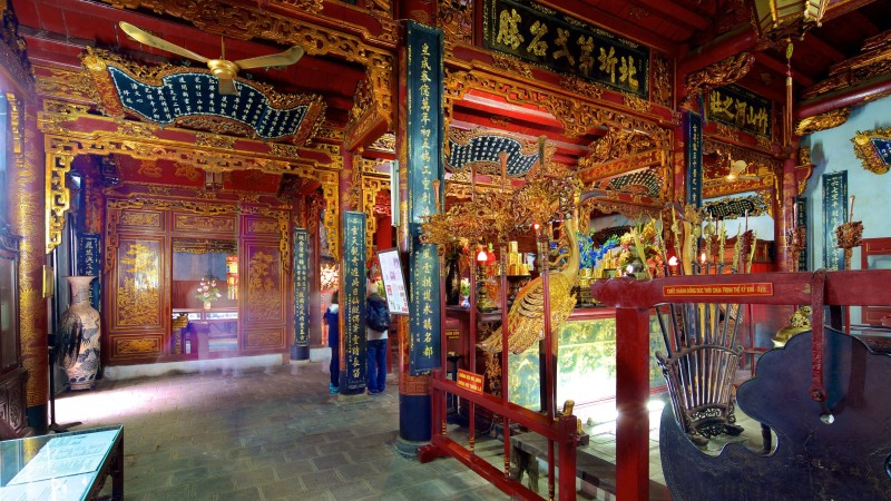 Elaborate Interior of Quan Thanh Temple with Wooden Carvings The intricate wooden carvings and ornate designs inside Quan Thanh Temple’s main hall, reflecting traditional Vietnamese artistry.