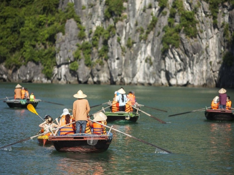 Family Adventures on Halong Bay Bamboo Boats A family enjoying a bamboo boat tour in Halong Bay’s calm waters.