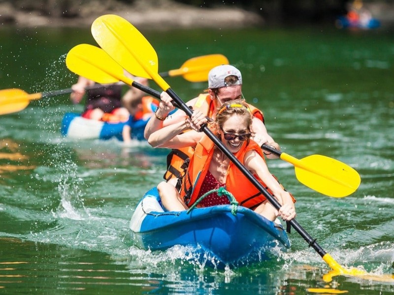 Families enjoying a kayaking adventure in the calm waters of Ha Long Bay.