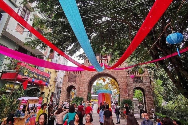 Festive Street Decorations in Van Phuc Silk Village Colorful silk banners hanging over a festive street in Van Phuc Silk Village during a silk festival.