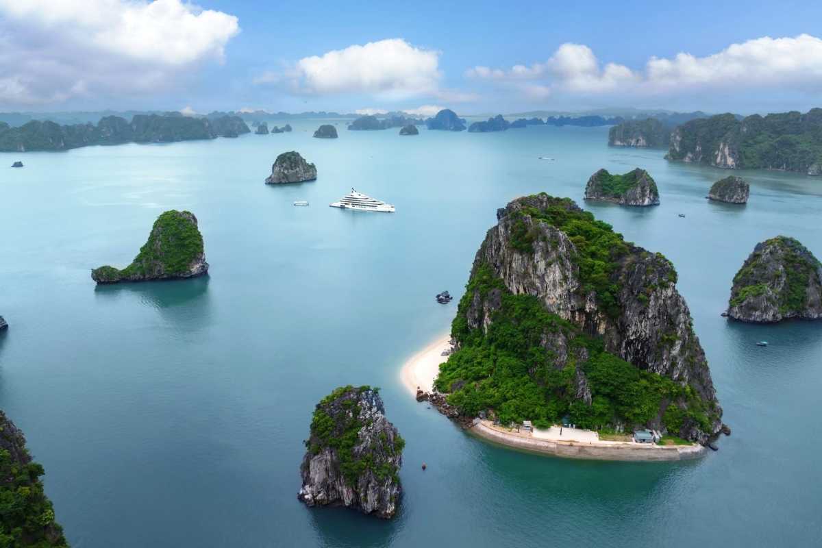 Aerial view of Fighting Cocks Islet Halong Bay surrounded by emerald waters and nearby islands