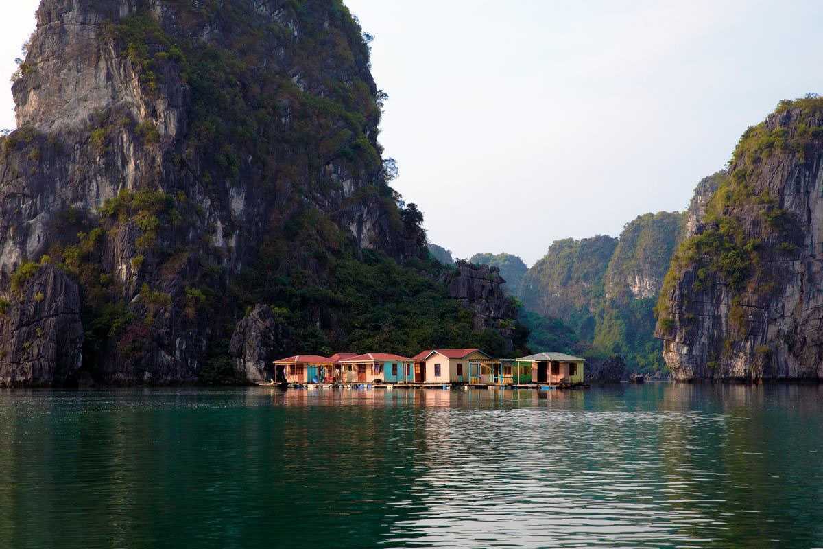 Fishing boats docked at the floating village near karst formations in Bai Tu Long Bay