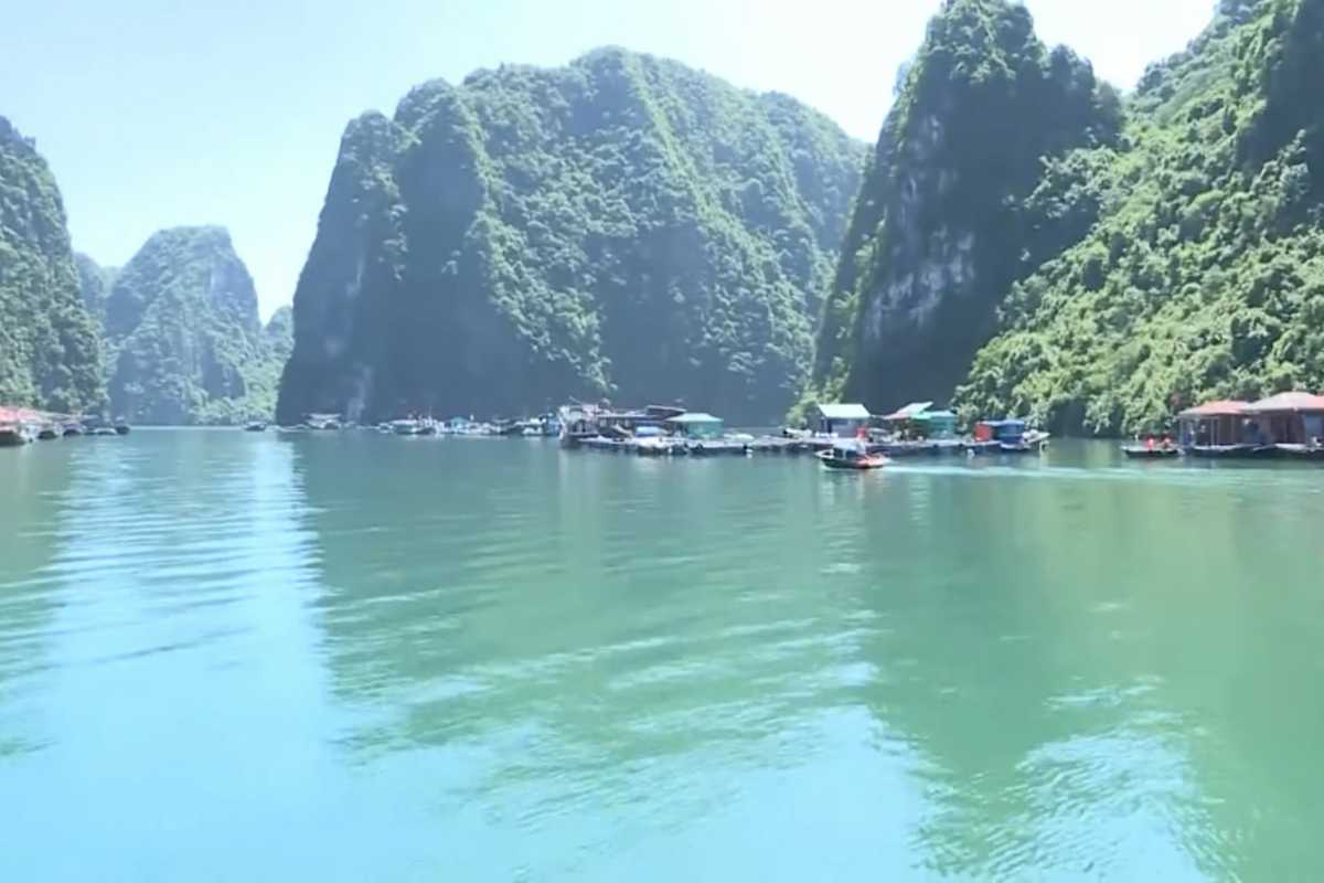 Cluster of floating houses surrounded by calm waters and karst formations at Cong Dam Fishing Village