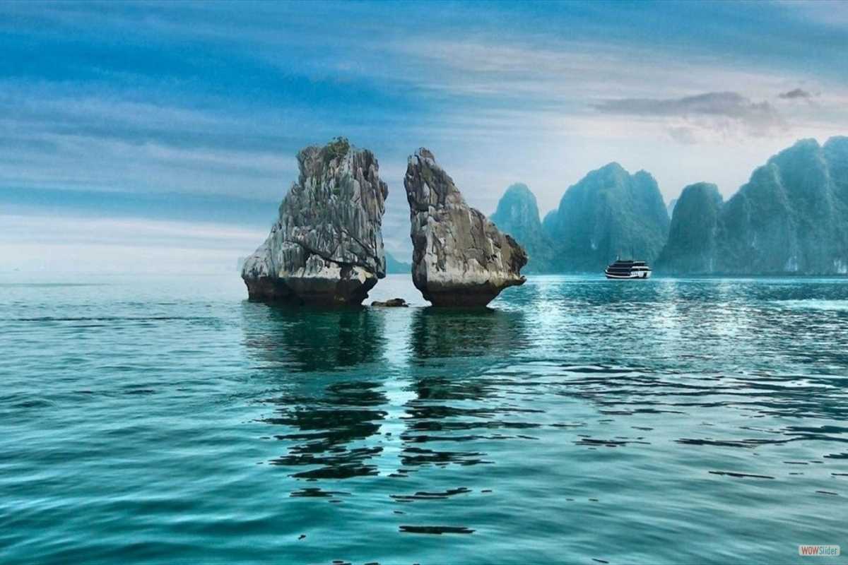 The famous twin rocks formation known as “Kissing Rocks” rising from calm waters in Ha Long Bay.