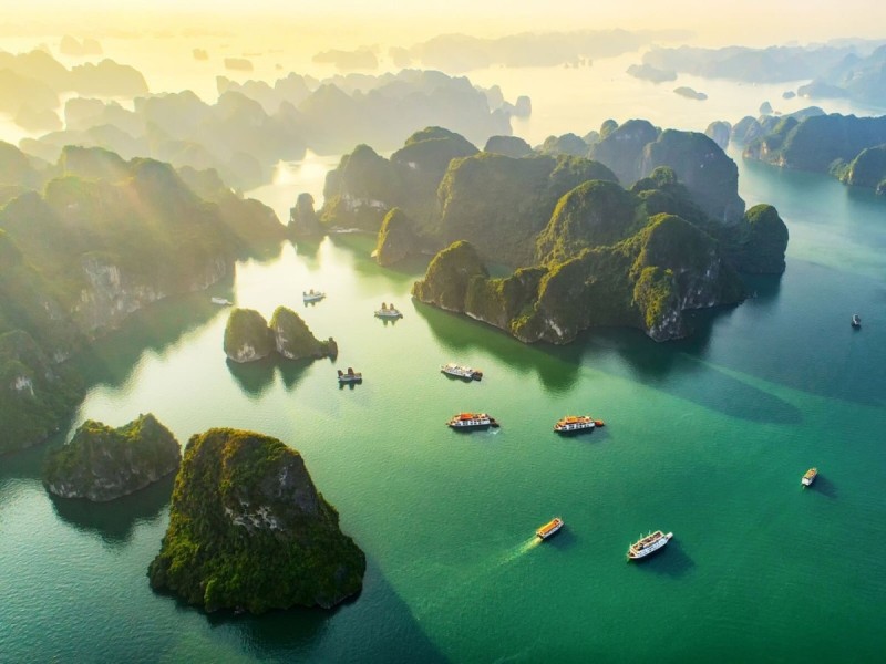Halong Bay Overview with Limestone Islands A stunning aerial shot of Halong Bay showcasing limestone islands and calm emerald waters under a clear blue sky.