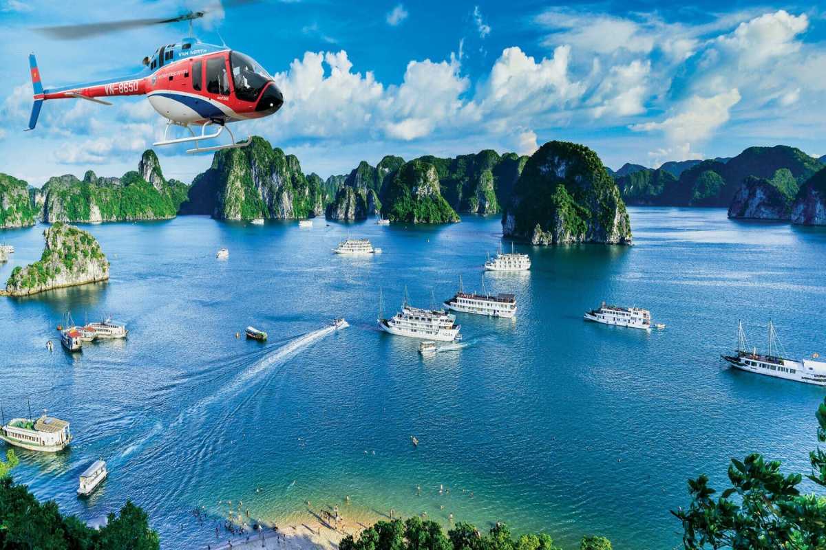 Tourist boats cruising near limestone islands in Halong Bay close to Drum Cave, offering scenic tours.
