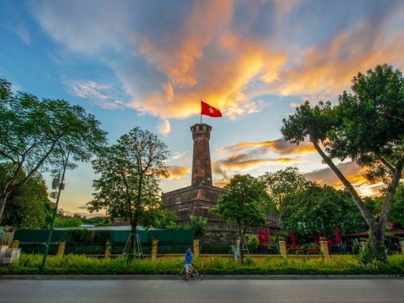 Hanoi Flag Tower at Sunset with the Vietnamese Flag Waving Hanoi Flag Tower at sunset with the Vietnamese flag waving against a vibrant sky.