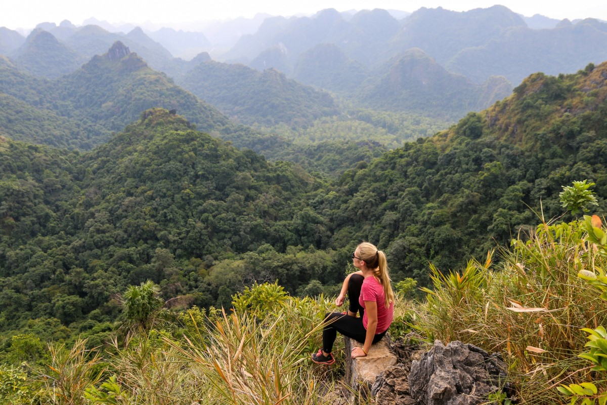 Woman sitting on a mountain peak overlooking Bai Tu Long National Park